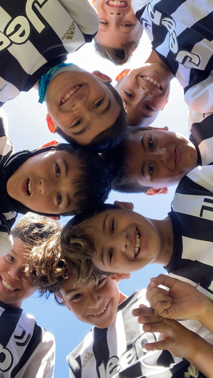Діти Juventus Academy обіймаються командою на футбольному полі